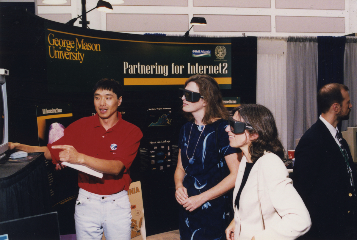 three people looking at an exhibit with special glasses on
