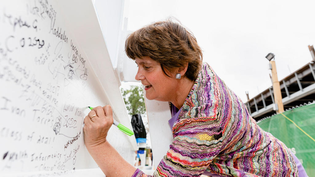 Anne Holton signs the commemorative steel beam to be installed as part of the construction of Mason's Horizon Hall